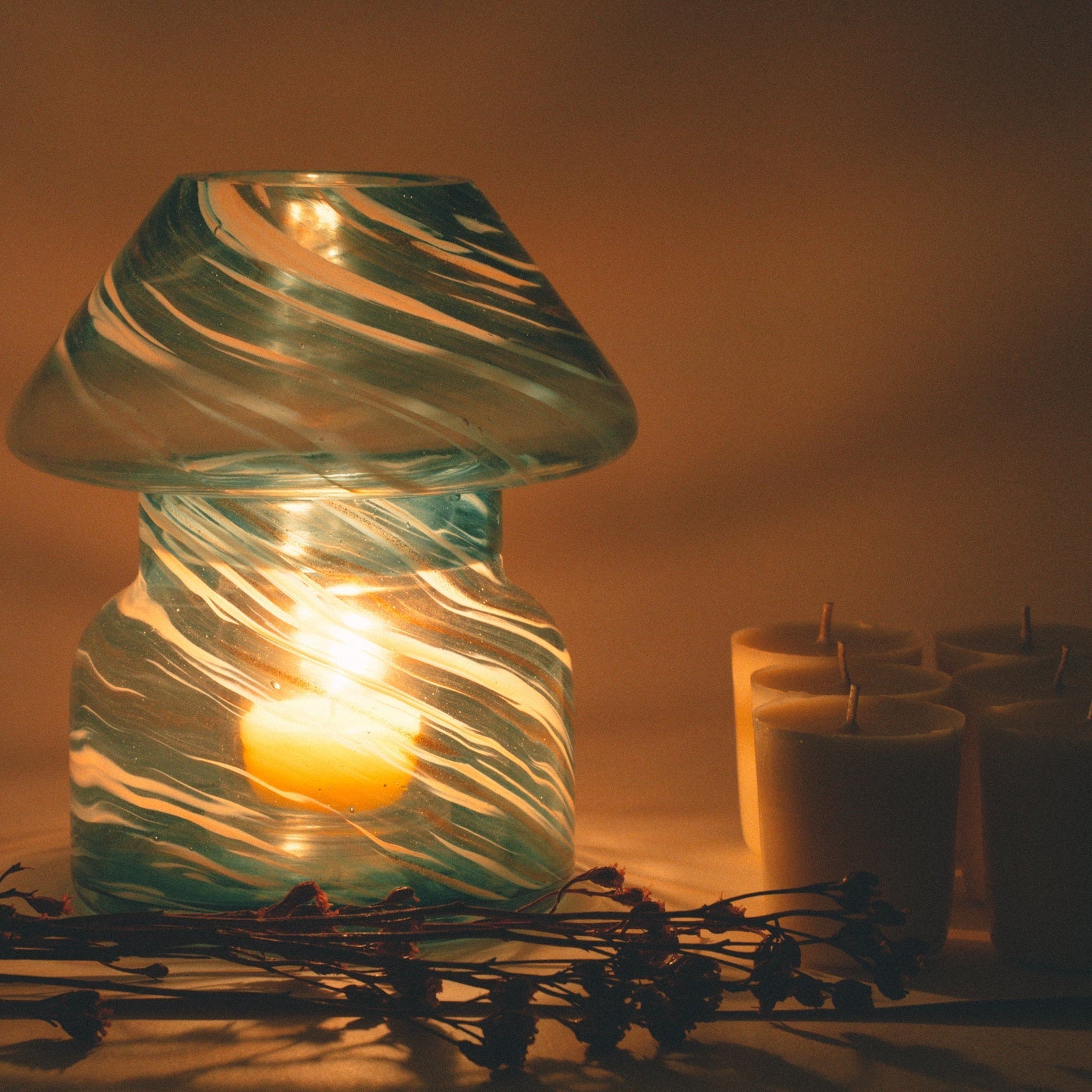 mushroom candle lamp refills next to lit sky blue candle lamp.