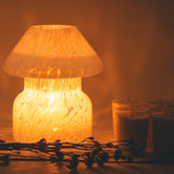 mushroom candle lamp refills next to lit cloud white candle lamp.