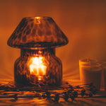 mushroom candle lamp refills next to lit leopard candle lamp.