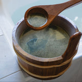 Wooden ladle scooping herbal bath soak from a Japanese bathing tool