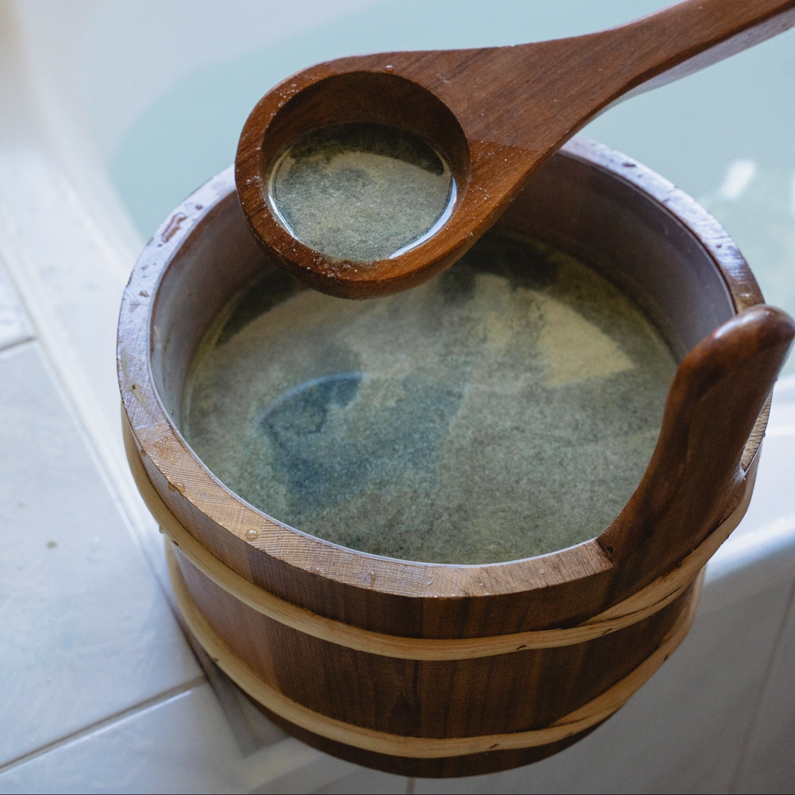 Wooden ladle scooping herbal bath soak from a Japanese bathing tool