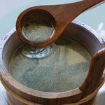Wooden ladle scooping herbal bath soak from a Japanese bathing tool