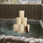 Hot spring with stone walls and wooden structure, candles stacked in the center.