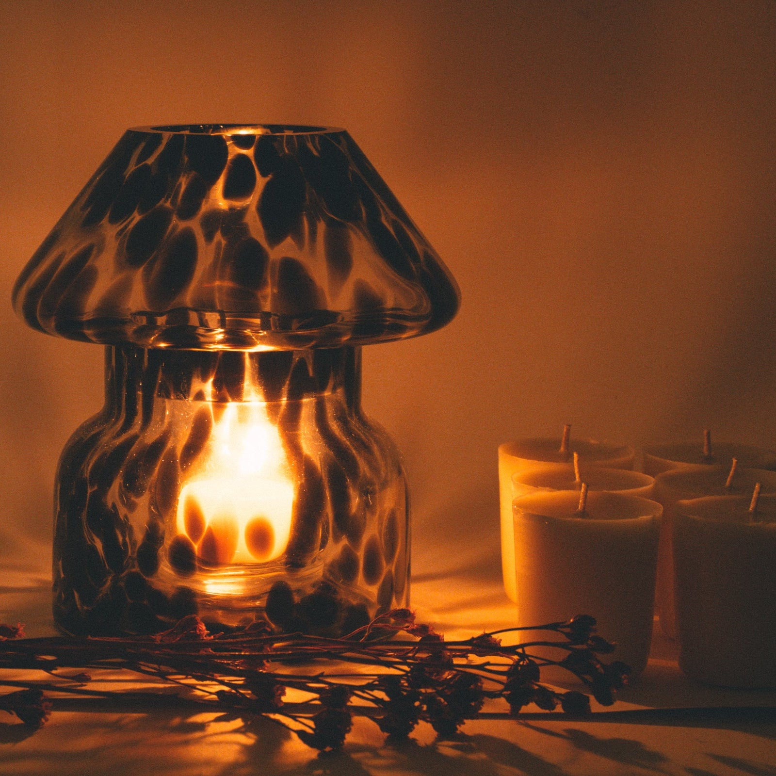 mushroom candle lamp refills next to lit ash candle lamp.