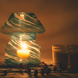 mushroom candle lamp refills next to lit sky blue candle lamp.