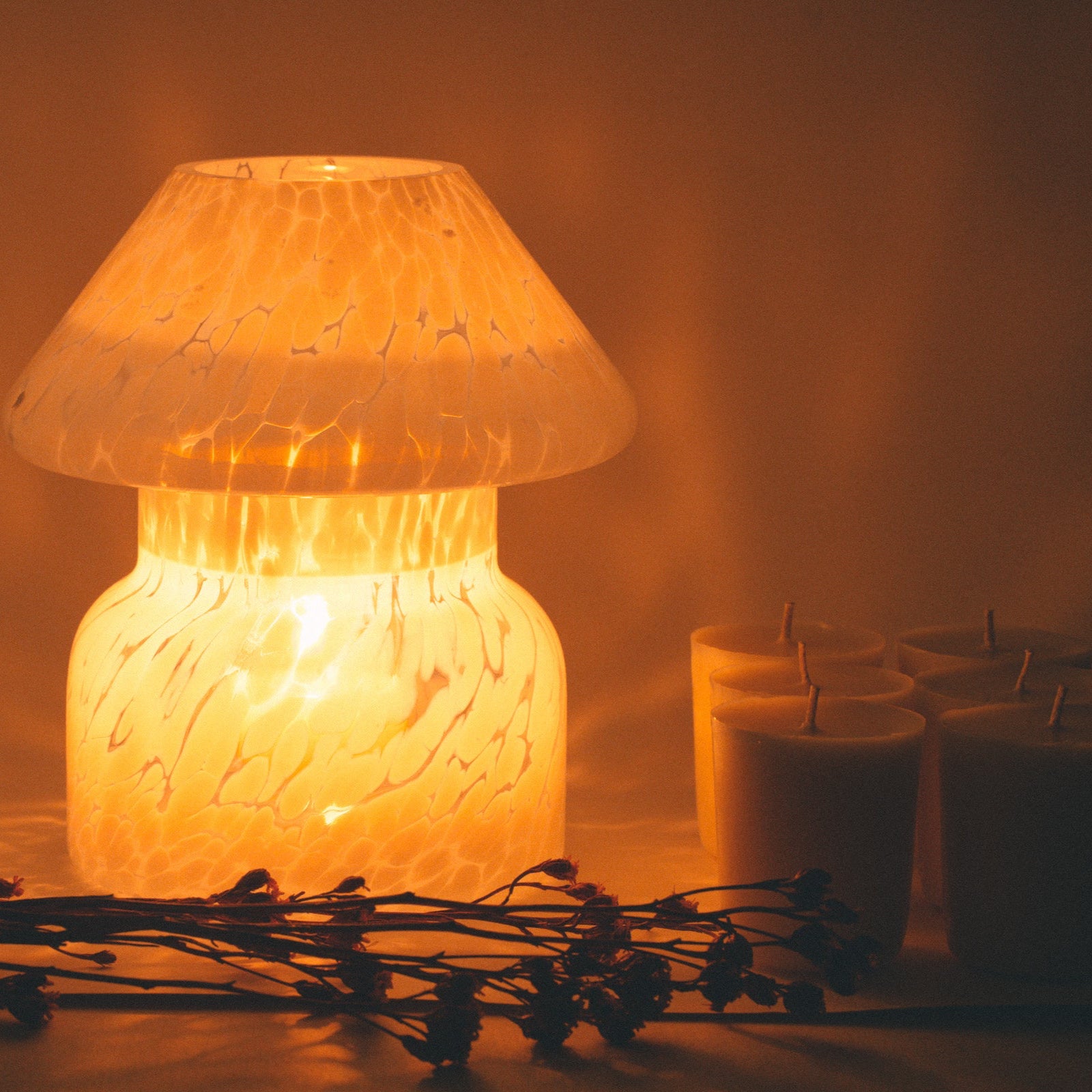 mushroom candle lamp refills next to lit cloud white candle lamp.